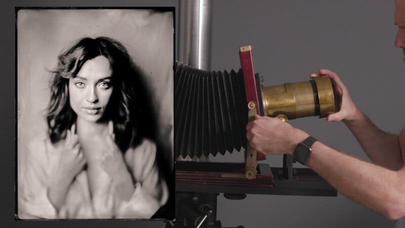 A person adjusts a large vintage camera with a brass lens. Next to the camera is a black and white portrait of a woman with wavy hair, looking directly at the camera, her hands near her face.