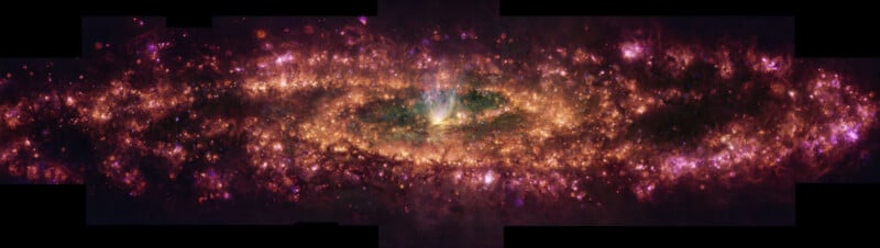 A vibrant, colorful image of a spiral galaxy seen edge-on, glowing with bright pink, purple, gold, and green hues, with dark dust lanes and a bright central bulge.