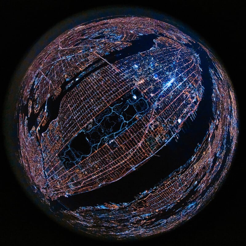A fisheye aerial view of a city at night, with streets and buildings illuminated by bright lights, forming a glowing grid pattern against the dark landscape. Central Park is visible as a dark rectangle amid the city.