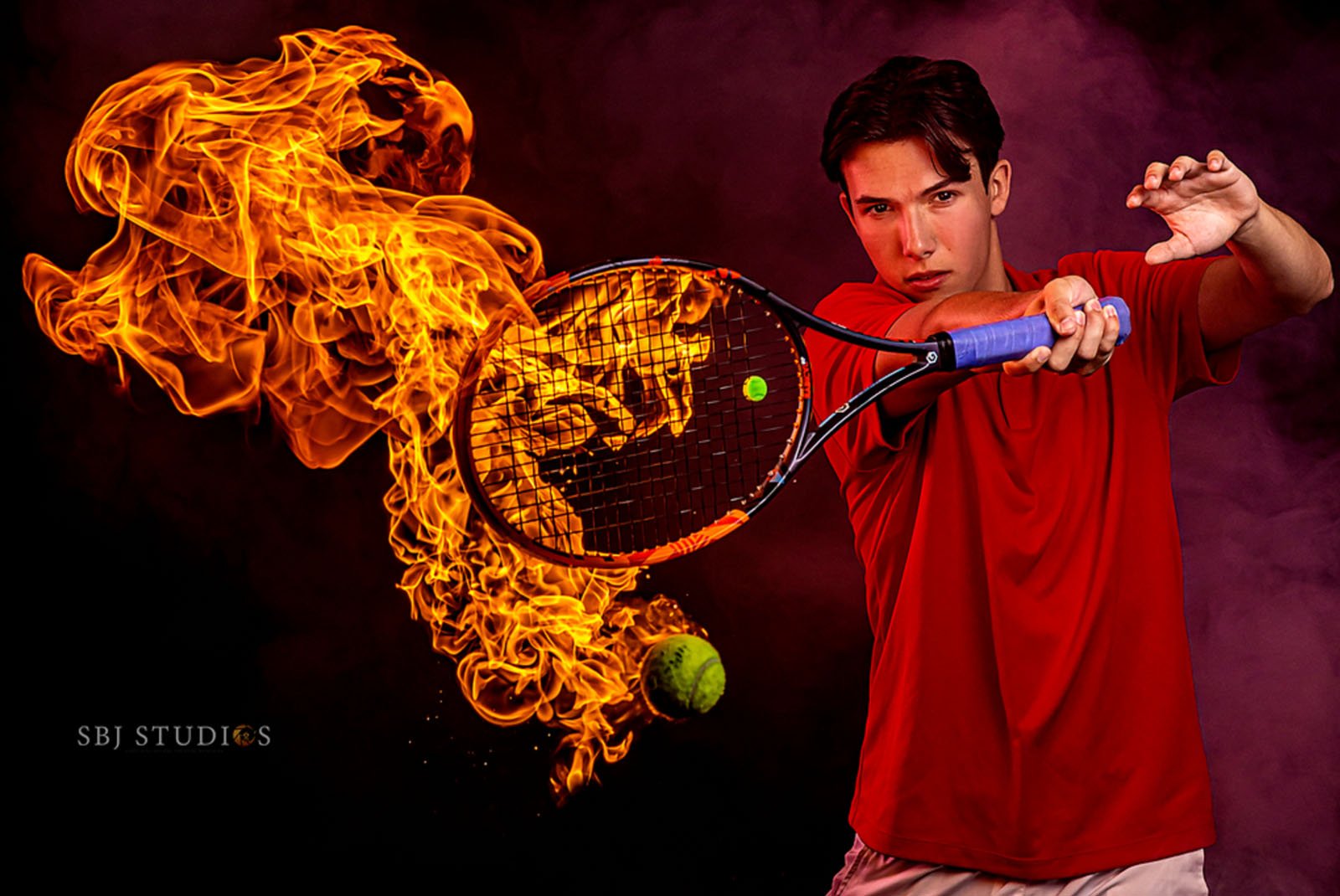 A man in a red shirt swings a tennis racket, hitting a tennis ball. Flames trail dramatically from the racket, creating a fiery effect. The background is dark with a misty atmosphere.